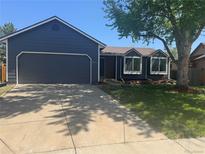 Charming single Gathering home with a well-manicured front yard, mature tree, and two car garage at 8491 W Star Cir, Littleton, CO 80128