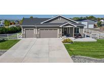 Charming home featuring a three-car garage, landscaped front yard, and inviting curb appeal at 505 Remington Dr, Hudson, CO 80642