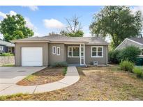 Ranch style home with a neutral exterior, single car garage, and landscaped yard at 1624 Yarrow St, Lakewood, CO 80214