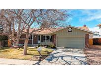 Charming ranch-style home with a well-maintained lawn, mature tree, and a two-car garage at 3387 S Pitkin Way, Aurora, CO 80013