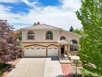 Charming two-story home showcasing a well-manicured lawn, a three-car garage, and beautiful arched windows under a bright sky at 4520 Maroon Cir, Broomfield, CO 80023