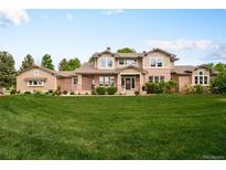 Beautiful two-story brick home features manicured lawn and well-maintained landscaping at 3502 Birch Ave, Parker, CO 80134