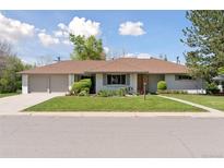 Charming single-story home featuring an attached two car garage and a beautifully maintained front lawn at 3775 S Forest Way, Denver, CO 80237