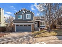 Charming two-story home featuring a well-maintained lawn, gray garage door and brick accents at 9742 Burntwood Ct, Highlands Ranch, CO 80126