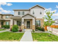 Charming two-story home with a stone-accented facade, inviting front porch and beautifully landscaped front yard at 11761 Cord Grass Way, Parker, CO 80138