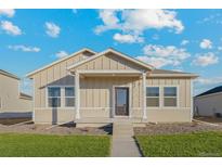 Charming single-story home featuring a covered porch, neutral siding, and a well-manicured lawn at 2986 Oxley St, Strasburg, CO 80136
