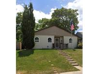 Charming single-story home featuring a well-manicured lawn and welcoming front entrance with an American flag at 1360 W Custer Pl, Denver, CO 80223