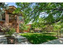 Beautiful brick home featuring a manicured lawn, lush landscaping, and charming curb appeal at 1934 S Sherman St, Denver, CO 80210