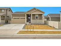 Inviting single-Gathering home featuring a covered front porch and a well-maintained lawn at 10525 Akron St, Commerce City, CO 80640