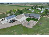 Stunning aerial view of a farmhouse with spacious garage and recreational area at 6331 County Road 32, Platteville, CO 80651
