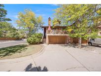 Charming two-story home featuring a balcony, multi-car garage, and mature trees creating a welcoming curb appeal at 1810 Youngfield Ct # A, Golden, CO 80401