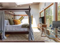 Comfortable main bedroom offers a canopy bed, desk, and expansive windows to enjoy the view at 167 Independence Cir, Breckenridge, CO 80424