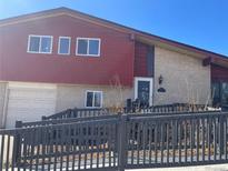 Charming home with a combination of brick and red siding, complemented by a fenced yard at 1473 S Monaco S Pkwy, Denver, CO 80224