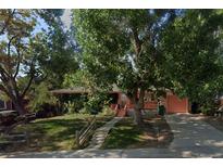 Charming single story home with a beautiful front yard, mature trees, covered porch, and a private driveway at 8319 Quivas Way, Denver, CO 80221