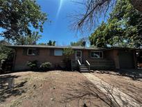 Charming single-story home with brick facade, grassy yard, and inviting front porch at 8319 Quivas Way, Denver, CO 80221