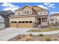 Charming two-story home featuring a two-car garage, stone accents, and a welcoming front porch at 10913 Ledges Rd, Parker, CO 80134