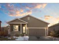 Ranch-style home with gray siding, two-car garage, and landscaping at 488 Vista Blvd, Brighton, CO 80603