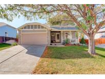 Charming home featuring a stone facade, two-car garage, inviting front porch and a well-manicured lawn at 16553 Gilpin St, Thornton, CO 80602
