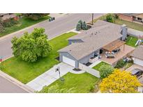 Aerial view of home featuring a long driveway, backyard patio, and mature trees on a large lot at 7155 E Exposition Ave, Denver, CO 80224