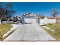 Single-story gray home featuring a spacious driveway and a basketball hoop for outdoor entertainment at 7155 E Exposition Ave, Denver, CO 80224