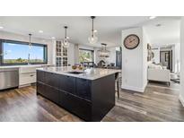 Open concept kitchen with a large center island with marble countertops and stainless steel appliances at 7388 S Ireland Cir, Centennial, CO 80016
