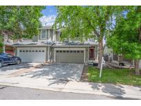 Inviting front exterior featuring a two-story townhome with a two car garage and mature landscaping at 9316 Harrison St, Thornton, CO 80229