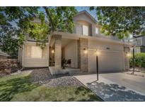 Charming two-story home featuring a well-manicured lawn and a welcoming front porch at 18647 E Berry Dr, Aurora, CO 80015
