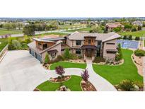 Beautiful exterior of a modern home with a basketball court, lush green lawn, and a three-car garage at 2466 Spruce Meadows Dr, Broomfield, CO 80023