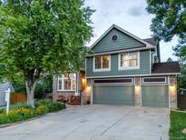 Inviting two-story home with a manicured lawn, a three-car garage, and a charming brick and wood facade at 601 E 131St Ct, Thornton, CO 80241