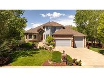 Beautiful two-story home with a well-manicured lawn, mature trees, and a two-car garage at 3935 Pierson St, Wheat Ridge, CO 80033