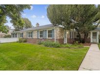Charming brick home with blue shutters and a well-manicured lawn at 1279 Leyden St, Denver, CO 80220