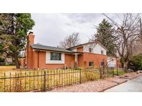 Charming two-story brick home with a well-maintained front yard and a quaint, covered porch entry at 589 Newark St, Aurora, CO 80010