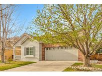 Charming home featuring a brick accent wall and a spacious two-car garage and nicely manicured front lawn at 19691 E 59Th Dr, Aurora, CO 80019