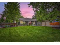 Charming single-story home with lush front lawn and mature trees at 2473 S Carr Ct, Lakewood, CO 80227