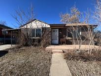 Brick ranch home with a covered patio and a spacious yard at 701 S Pecos St, Denver, CO 80223