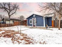 Charming blue single-story home featuring a welcoming front door and snow-covered yard at 2852 W Ellsworth Ave, Denver, CO 80219