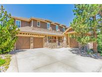 Charming home featuring a three-car garage and beautiful stone accents enhancing the exterior's curb appeal at 6761 Mary Ct, Castle Pines, CO 80108