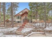 Stunning home featuring a stone facade, exposed timber accents, and a welcoming entryway with rustic wreath at 1662 Gore Dr, Larkspur, CO 80118