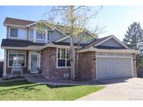 Charming two-story home with a stone facade, well-manicured lawn, and a two-car garage at 9684 W Long Dr, Littleton, CO 80123