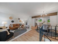 Bright living room featuring a modern design, hardwood floors, and seamless flow into the adjacent kitchen at 116 Monarch St, Louisville, CO 80027