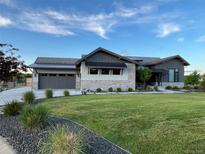 Beautifully landscaped front yard of a home with stone accents and a well-manicured lawn at 6736 S Flanders Ct, Aurora, CO 80016
