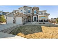 Beautiful two-story home featuring stone accents, a two-car garage, and well-maintained landscaping at 21854 Tyrolite Ave, Parker, CO 80138