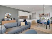 This modern living room features an open floor plan with a sleek kitchen and dining area, and comfortable seating at 1300 N Ogden St # 304, Denver, CO 80218
