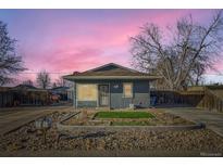 Charming single-story home with a well-maintained front yard and blue paint at 7051 E 75Th Ave, Commerce City, CO 80022