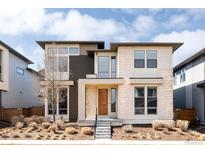 Modern home featuring stone accents, a stylish front door, and professionally landscaped front yard at 6021 N Boston Ct, Denver, CO 80238