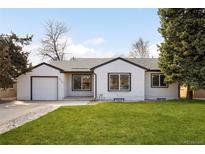 Charming, light-colored, single-story home with a well-maintained lawn and a traditional-style attached garage at 2839 Ivanhoe St, Denver, CO 80207
