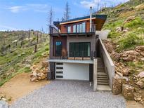 Modern exterior featuring a two-story design, a ground-level garage, and a second-story balcony with metal railings at 718 Emerson Gulch Rd, Boulder, CO 80302
