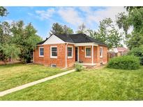 Charming red brick home with a well-manicured lawn and mature trees at 2970 Leyden St, Denver, CO 80207