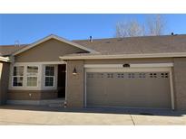 Charming home featuring a neutral color palette, brick accents, and an attached garage with carriage-style doors at 15346 Heritage Cir, Thornton, CO 80602