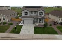 Beautiful two-story home featuring solar panels, a well-manicured lawn, and an attached two car garage at 7414 Blue River Ave, Frederick, CO 80530